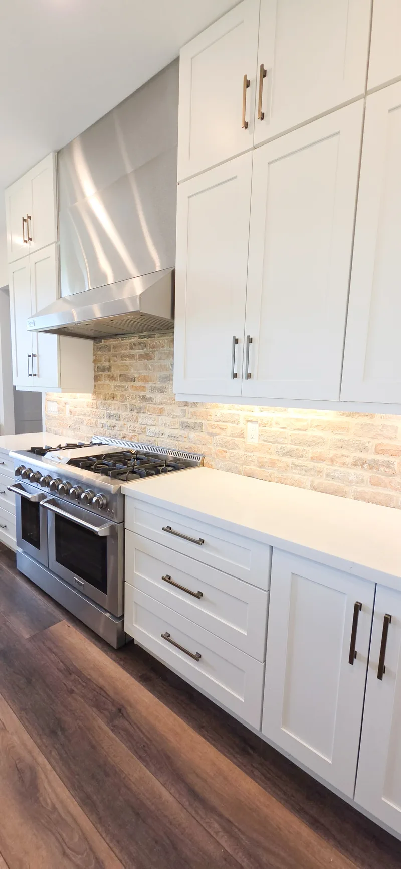 White shaker cabinets with under-cabinet lighting and pro-style range, Valley AZ