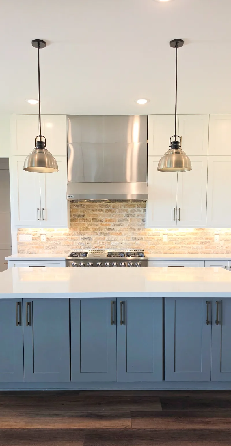 Professional gas range with stainless hood and brick backsplash, Valley AZ